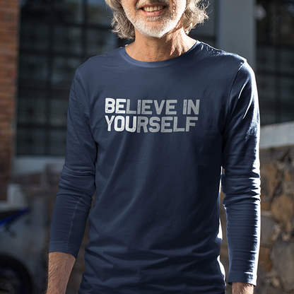 A confident woman leans forward in the BElieve in YOUrself Premium Sober Apparel long-sleeve shirt, showcasing a message of strength, hope, and resilience.