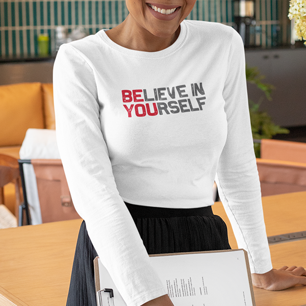 A woman wears the BElieve in YOUrself Premium Sober Apparel long-sleeve, sharing a message of hope and personal growth.