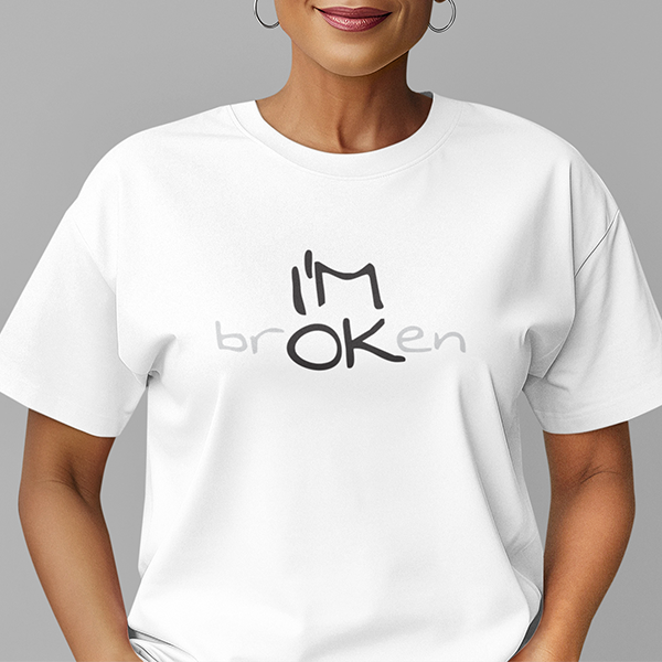 I'M brOKen Premium Sober Apparel worn by a woman in a white t-shirt, featuring a hidden "I'M OK" message that reflects resilience, recovery, and the hope found through healing.