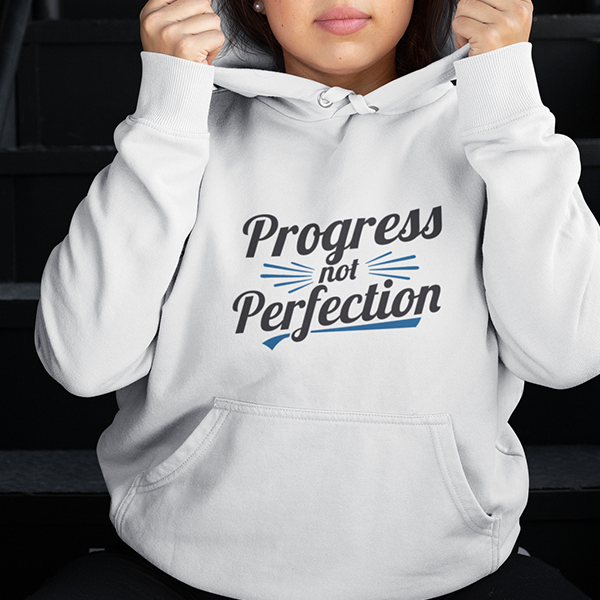 Person wearing a hoodie with the text 'Progress not Perfection' representing Progress Not Perfection Premium Sober Apparel.
