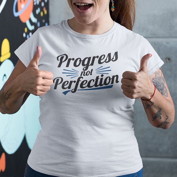 Woman giving thumbs up while wearing Progress Not Perfection Premium Sober Apparel t-shirt.